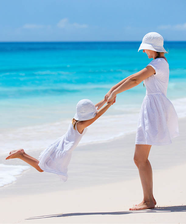 Mother and daughter having fun at tropical beach