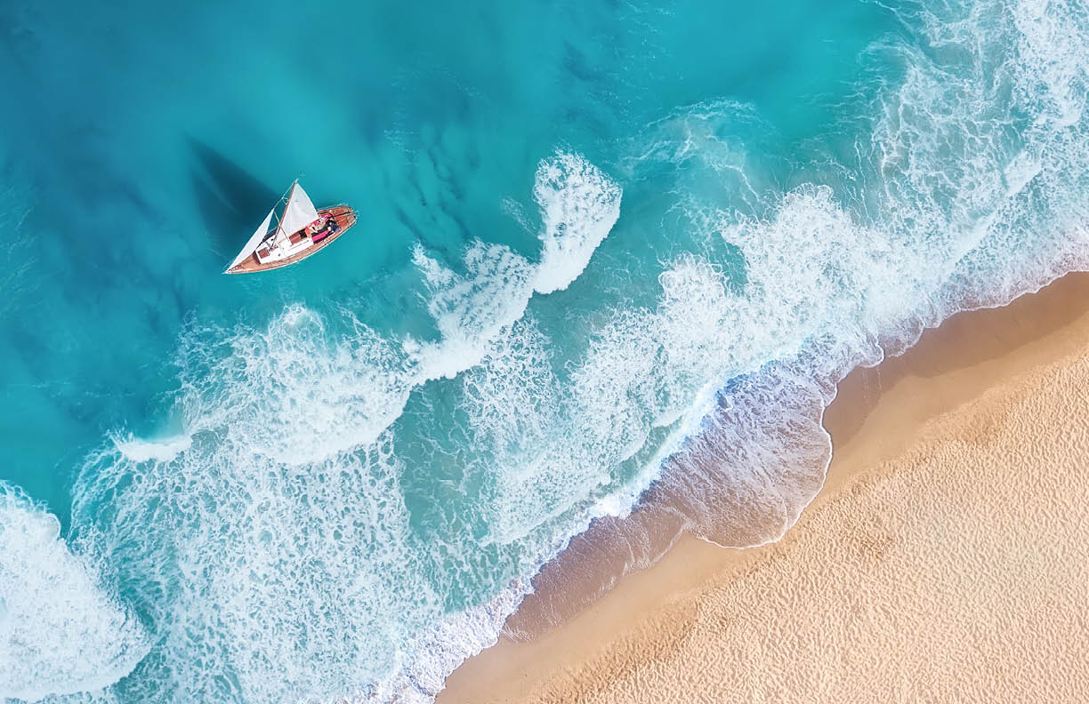 Waves and yacht from top view. Turquoise water background from top view. Summer seascape from air. Top view from drone. Travel-image