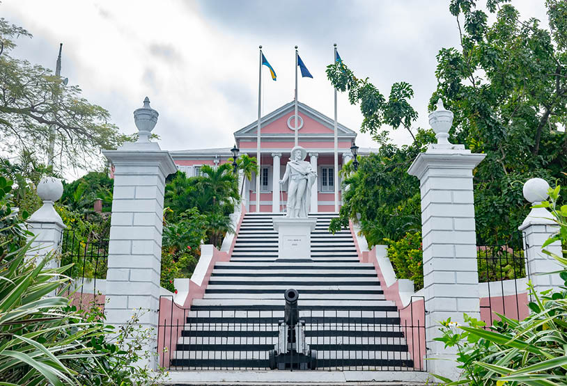 Nassau, Bahamas - December 02 2015: The Government House in Nassau, Bahamas, painted in pink, with statue of Christopher Columbus on the staircase