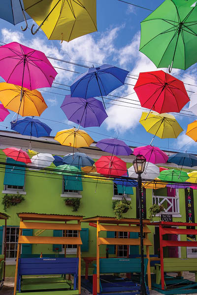 Nassau, Bahamas - May 30, 2019: Colorful umbrellas shading the tourist precinct of West Hill St in Nassau city, with its art galleries, cafes and Graycliff Hotel.