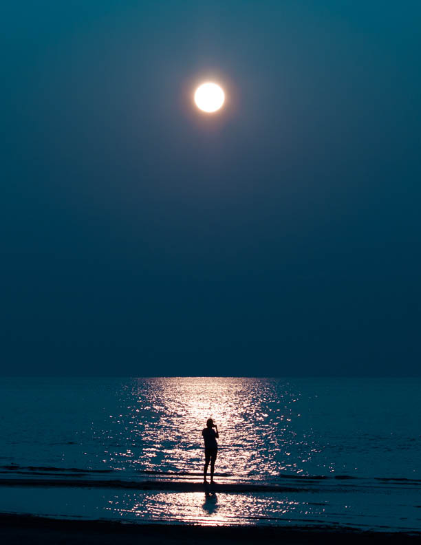 Someone is talking on the phone. the moon in the sky. moonlit road to the sea