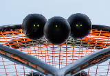 Squash balls on the background of a squash racket with a mirror image. Squash equipment for game.