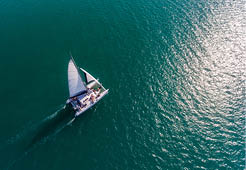 A catamaran moves through the teal waters of the Caribbean.