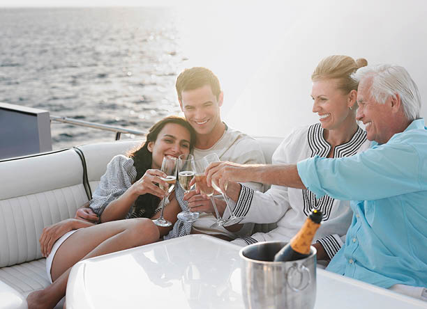 Two generational family celebrating with champagne on yacht