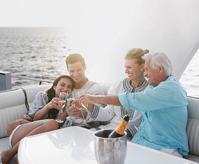 Two generational family celebrating with champagne on yacht