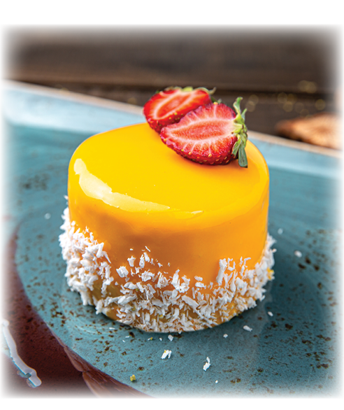 Dessert soft mango mousse or peach and strawberry. Menu for a restaurant. Beautiful composition on wooden boards.