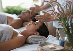 Hands, head massage and couple in spa to relax on bed for luxury pamper treatment together in hotel. Beauty, facial or zen woman with man at resort or salon for natural healing benefits or skincare