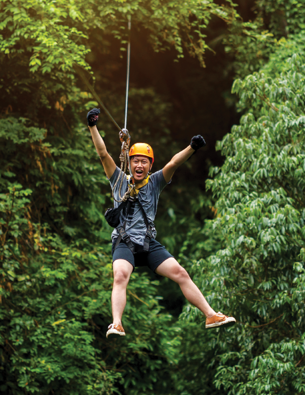 Freedom Man Tourist Wearing Casual Clothing On Zip Line Or Canopy Experience In Laos Rainforest, Asia