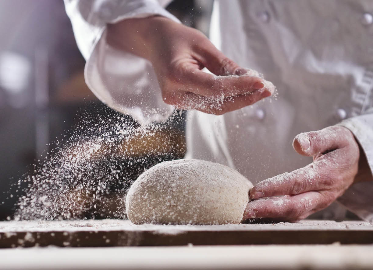 An experienced chef in a professional kitchen prepares the dough with flour to make the bio Italian pasta. the concept of nature, Italy, food, diet and bio.