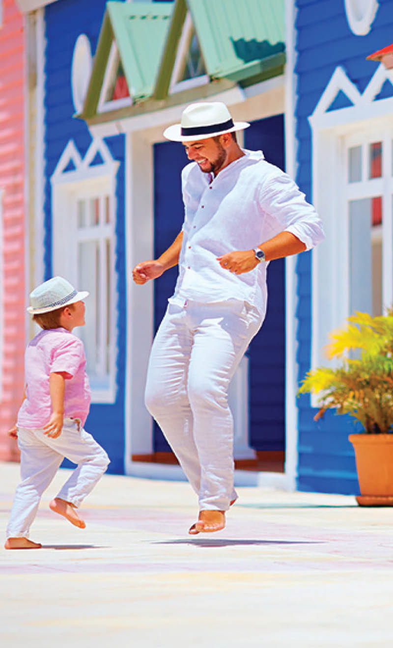 happy father and son enjoy life, dancing on caribbean village street