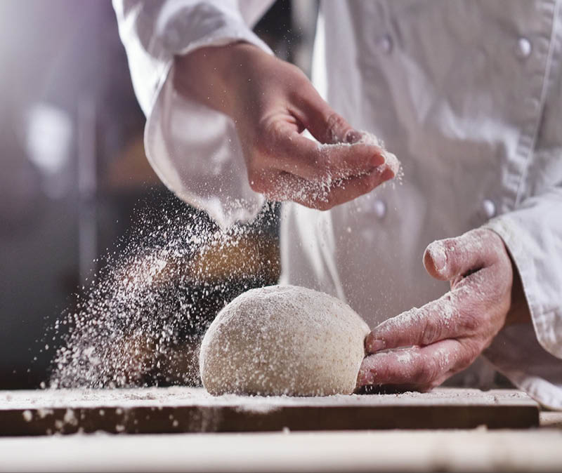 An experienced chef in a professional kitchen prepares the dough with flour to make the bio Italian pasta. the concept of nature, Italy, food, diet and bio.