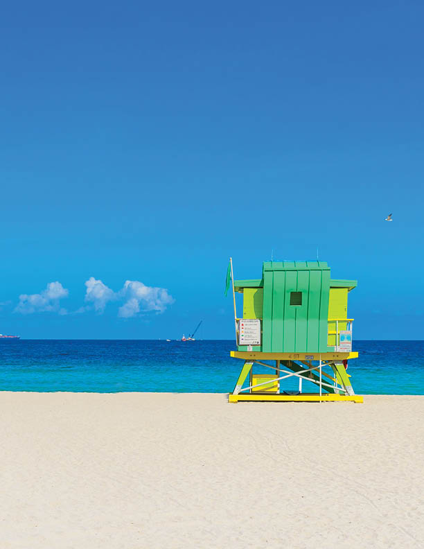 Miami South Beach, lifeguard house in a colorful Art Deco style at sunny summer day with the Caribbean sea in background, world famous travel location in Florida, USA