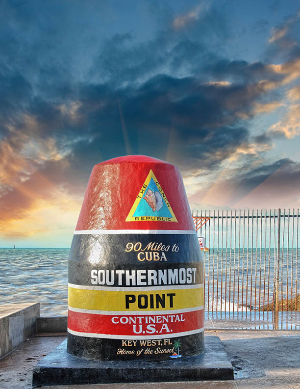 Southernmost Point sign in Key West, Florida. Beautiful seascape with sunset sky.