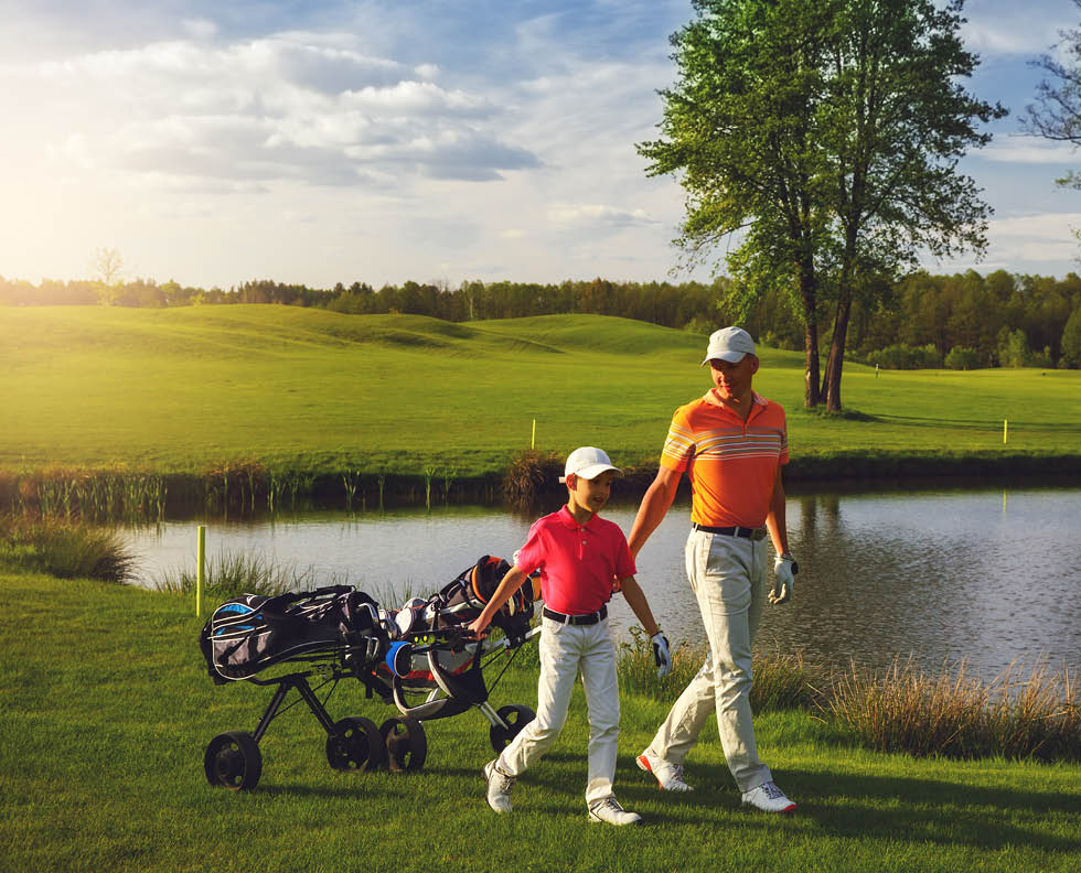 Father with son are walking at golf field