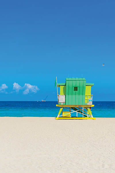 Miami South Beach, lifeguard house in a colorful Art Deco style at sunny summer day with the Caribbean sea in background, world famous travel location in Florida, USA