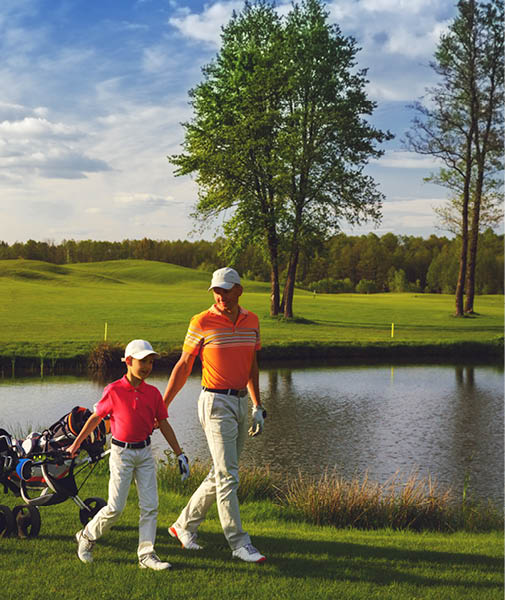 Father with son are walking at golf field