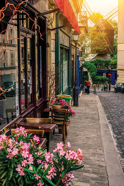 Cozy street with tables of cafe and old mill in quarter Montmartre in Paris, France. Architecture and landmarks of Paris. Postcard of Paris