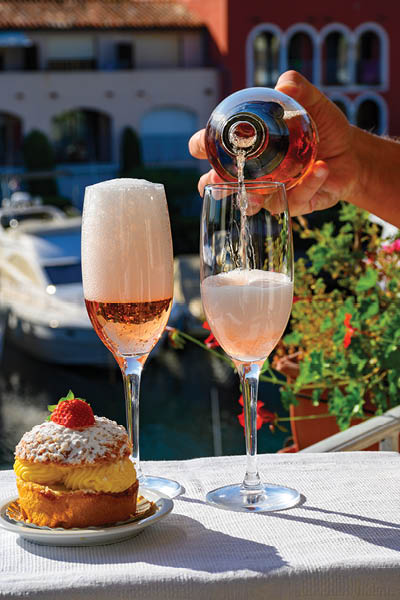 Summer party, drinking of French brut rose champagne sparkling wine in glasses in yacht harbour of Port Grimaud near Saint-Tropez, French Riviera vacation, Var, France