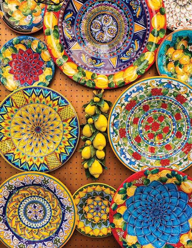 Collection of colorful Italian ceramic pottery, local craft products from Positano, Italy. Ceramic plates display in Positano, Italy. Colorful of vintage ceramic plates in Positano, Italy.