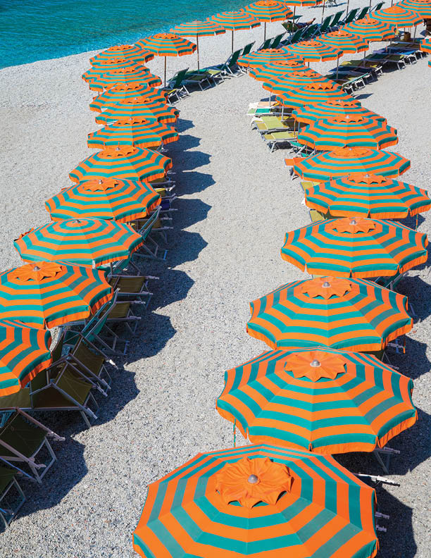 Rows of orange & green umbrellas on the beach