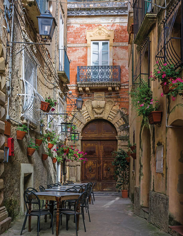 Cafe tables and chairs outside in old cozy street in the Positano town, Italy