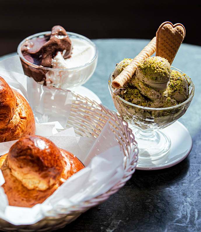 Sicilian breakfast with pistachio gelato, almond and chocolate granita, brioches. On bar table in the sun_2 