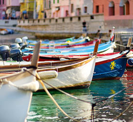 Colourful fishing boats in small marina of Vernazza, one of the five centuries-old villages of Cinque Terre, located on rugged northwest coast of Italian Riviera, Liguria, Italy.