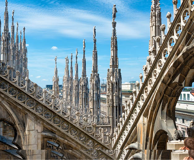 White marble statues on the roof of famous Cathedral Duomo di Milano on piazza in Milan, Italy 