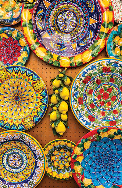 Collection of colorful Italian ceramic pottery, local craft products from Positano, Italy. Ceramic plates display in Positano, Italy. Colorful of vintage ceramic plates in Positano, Italy.