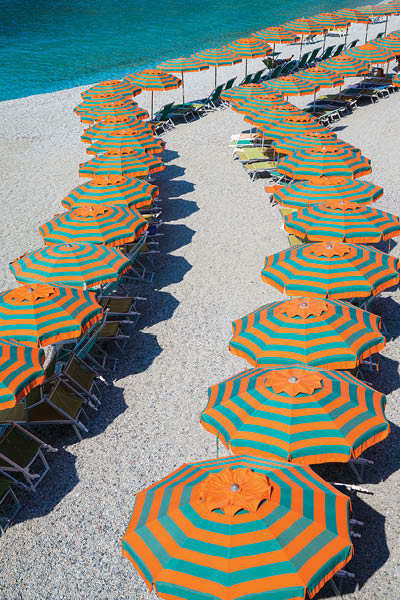 Rows of orange & green umbrellas on the beach