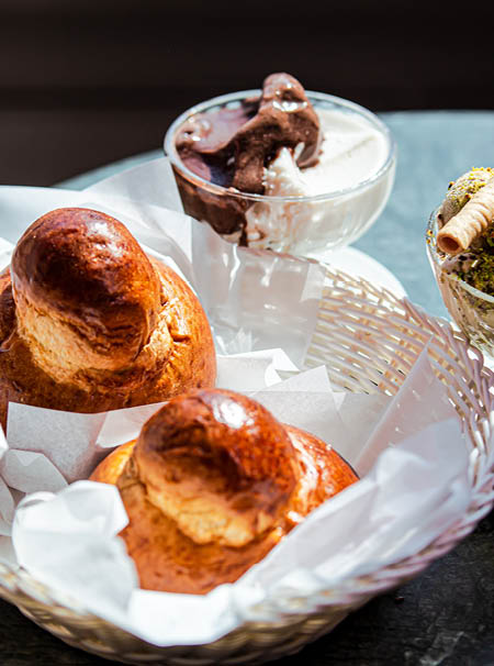 Sicilian breakfast with pistachio gelato, almond and chocolate granita, brioches. On bar table in the sun_2 