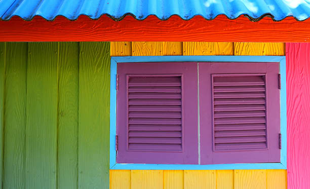 Beach style Caribbean house painted with primary colors in reggae decorative style