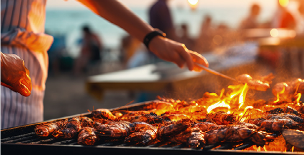 Chef grills seafood on beach for dinner roasted seafood party Grilled lobster and king prawns squid on bbq fire Thai street food night market Copy space image Place for adding text or design