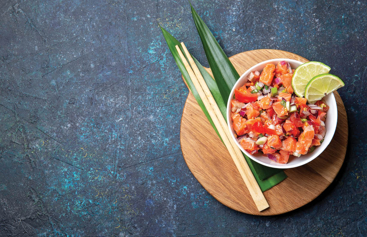 Lomi lomi salmon, hawaiian raw salmon salad on blue background