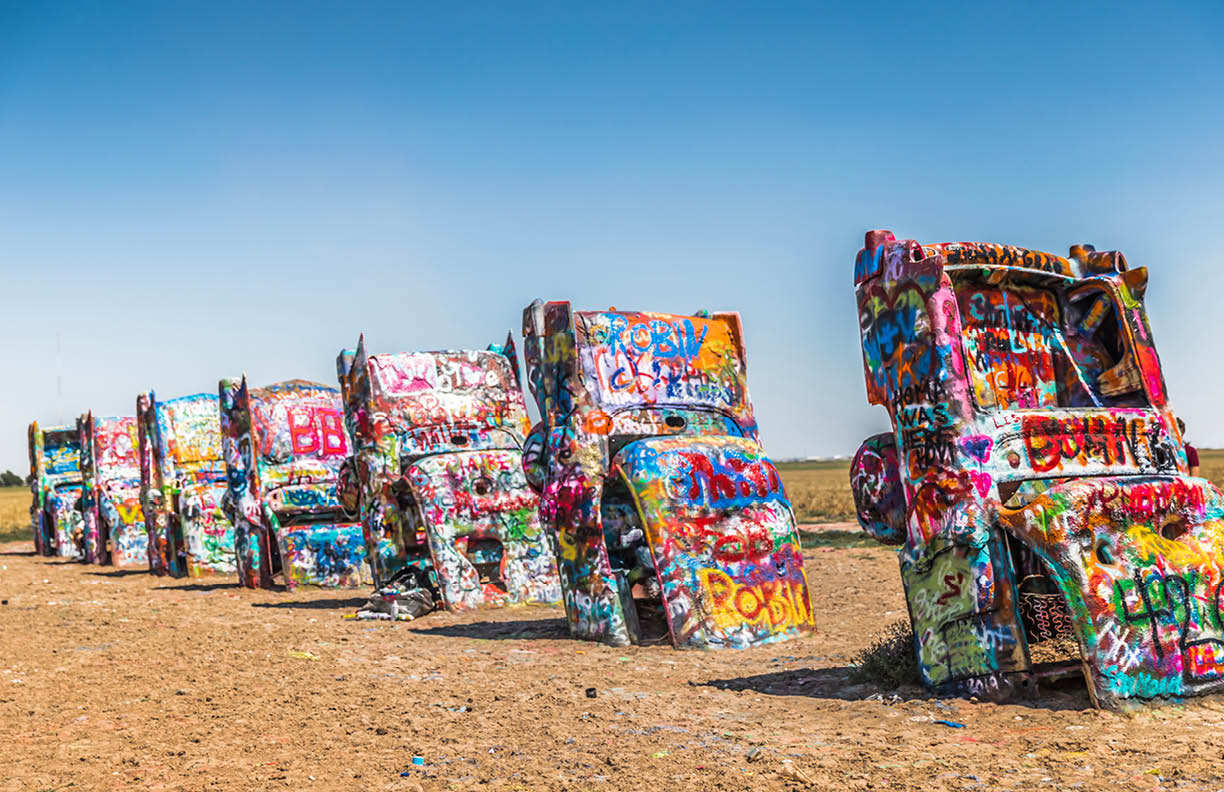 Amarillo, Texas / USA - July 24, 2019: Cadillac Ranch, located along I-40, is a public art sculpture of antique Cadillacs buried nose-down in a field.