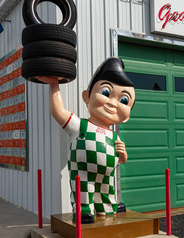 Galena, Kansas - United States - June 18th, 2025: Bob's Big Boy statue holding tires at Gearhead Curios tourist attraction on historical Route 66 in Galena, Kansas, USA.