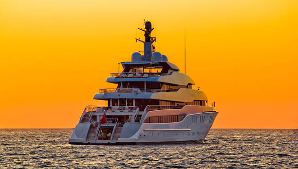 Luxury yacht on open sea at golden sunset