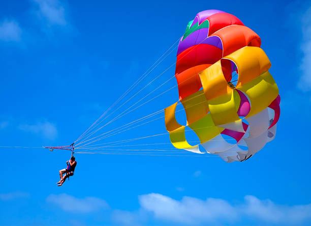 A parachute being towed at sea with a clear blue sky in the background.