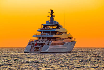 Luxury yacht on open sea at golden sunset
