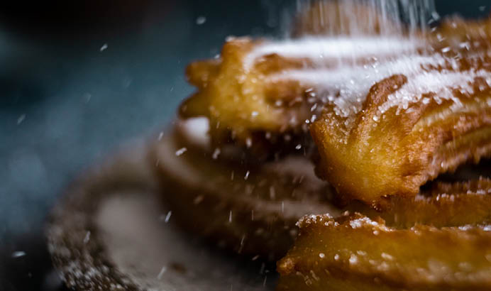 Typical churros with sugar and hot chocolate in a autumn morning