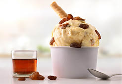 Raisins ice cream cup on white table homemade with kitchen background. Horizontal composition. Front view.