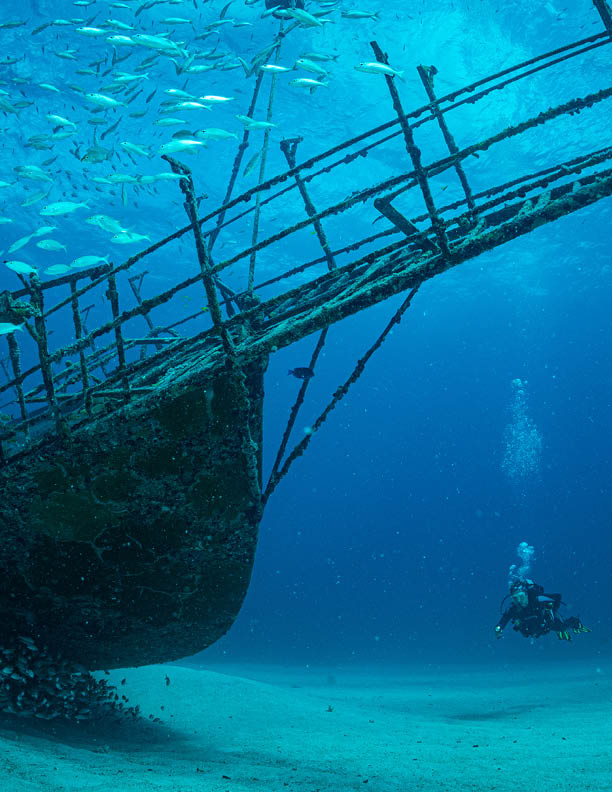Women diver explores the wrecks at the Bridge dive site on the island of Sint Maarten, Dutch Caribbean
