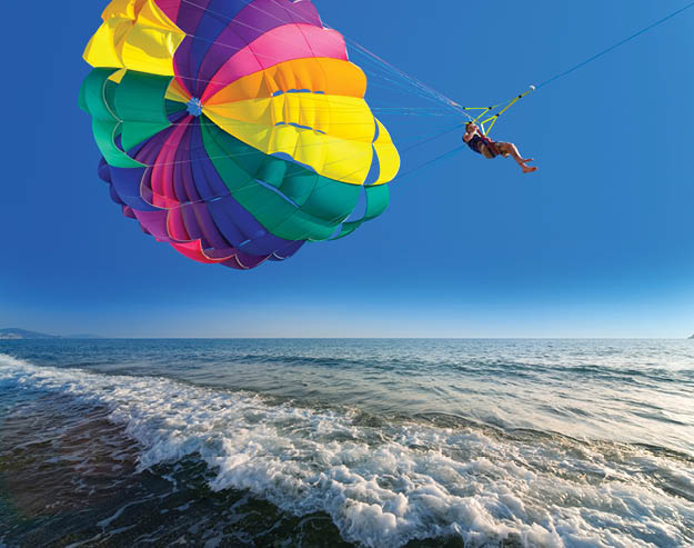 Man is parasailing in the blue sky