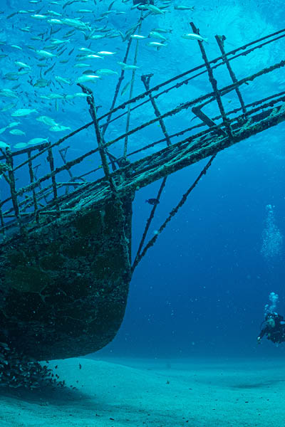 Women diver explores the wrecks at the Bridge dive site on the island of Sint Maarten, Dutch Caribbean