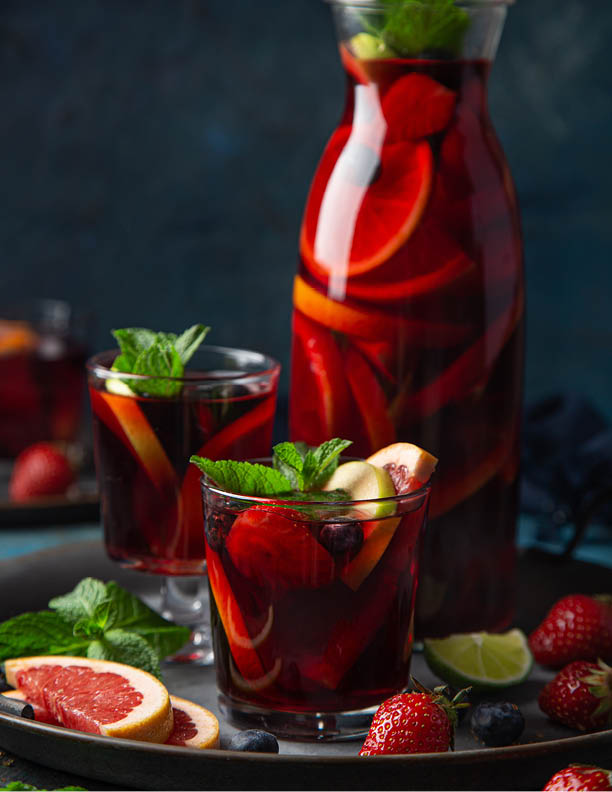 glass of homemade red wine sangria with fruits and berries, selective focus, dark background