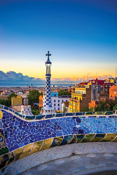 View of mosaic tile in Summer Park Guell and Barcelona cityscape in the background, Spain