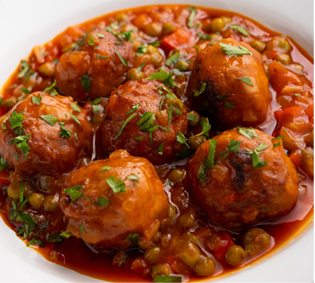 Veal meatballs in sauce with peas and tomato. Traditional Basque country tapas in the north of Spain.