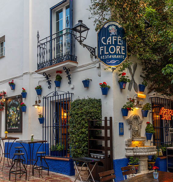 Marbella, Spain; February 29 2024: The photograph captures a charming street in Marbella, where the white walls of the buildings contrast with the vibrant colors of the flowers