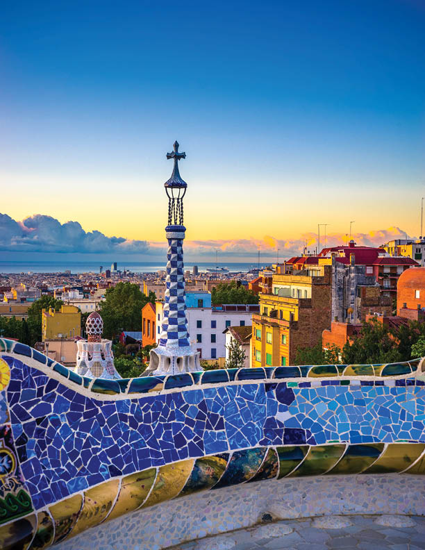 View of mosaic tile in Summer Park Guell and Barcelona cityscape in the background, Spain