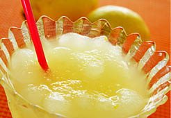 a glass with spanish granizado de limon, a semi frozen dessert made with lemon juice and sugar, similar to shaved ice or sorbet